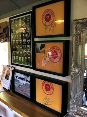 Three Signed Cycling Tee Shirts Framed and Displayed in Shart Original T-Shirt Frames at Stan’s Bike Shack in Australia.