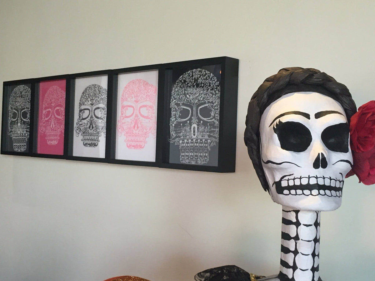 5 Day of the Dead Tee Shirts Framed and Displayed in Shart Original T-Shirt Frames next to skeleton