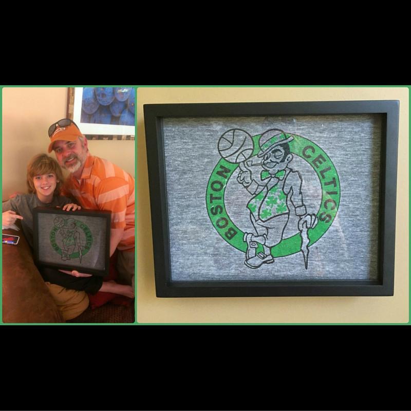 Smiling Father and Son holding framed Boston Celtics tee shirt displayed in a gifted Shart Original T-Shirt Frame